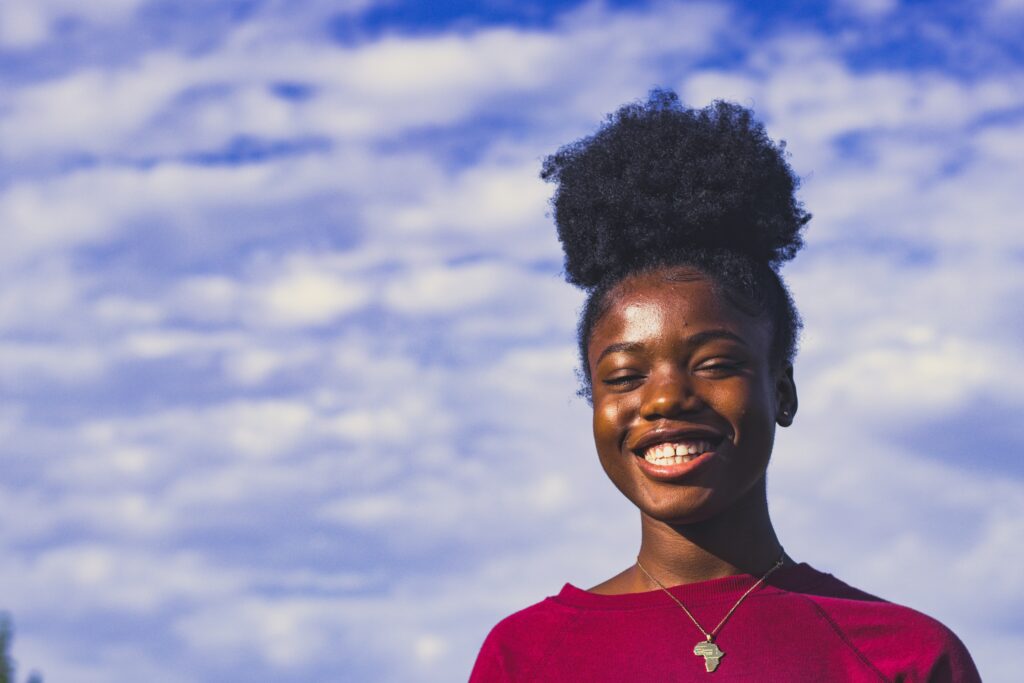 A woman experiencing joy with a blue cloudy sky in the background
